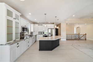 Kitchen featuring a center island, white cabinets, backsplash, appliances with stainless steel finishes, and recessed lighting