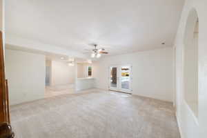 Unfurnished room featuring baseboards, french doors, ceiling fan, and light colored carpet