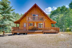 Back of house featuring a deck and a balcony