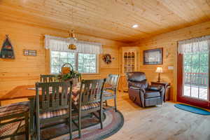 Dining space featuring a wealth of natural light, wooden walls, and wood ceiling