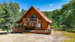 Back of house featuring metal roof and a deck