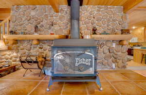 Details featuring white appliances, a wood stove, and wood ceiling
