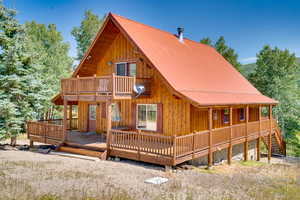 Rear view of property with a balcony, board and batten siding, and metal roof