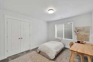Carpeted bedroom with baseboards, a closet, and visible vents