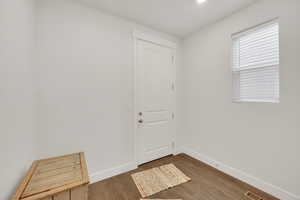 Doorway to outside featuring wood finished floors and baseboards