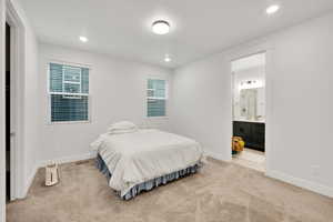 Bedroom with light colored carpet, baseboards, and recessed lighting