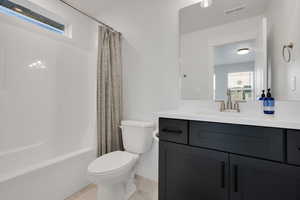 Full bathroom featuring toilet, shower / tub combo with curtain, visible vents, marble finish floor, and vanity