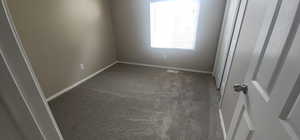 Spare room featuring baseboards, carpet flooring, and visible vents