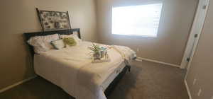 Bedroom featuring baseboards, dark carpet, and visible vents
