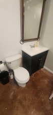 Half bath with vanity, toilet, and baseboards
