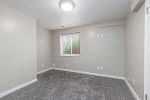 Empty room with dark carpet and baseboards