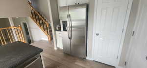 Kitchen featuring baseboards, stainless steel refrigerator with ice dispenser, and dark wood finished floors