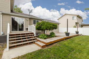 Rear view of house with a wooden deck and central AC