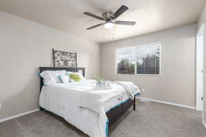 Bedroom with carpet, baseboards, and a ceiling fan