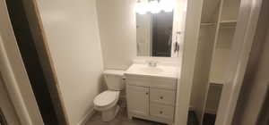 Bathroom featuring toilet, baseboards, and vanity basement bathroom
