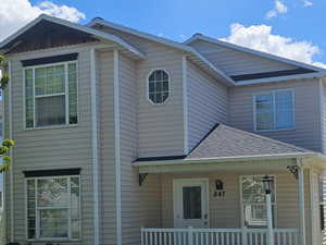 View of front of property featuring a porch and a front yard