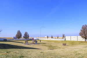 Community play area featuring a yard and fence