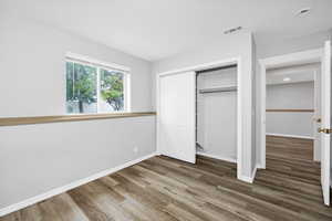 Basement bedroom featuring wood finished floors, baseboards, a closet, and recessed lighting