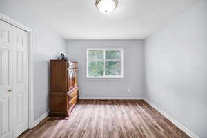 Master bedroom featuring wood finished floors and door to bathroom