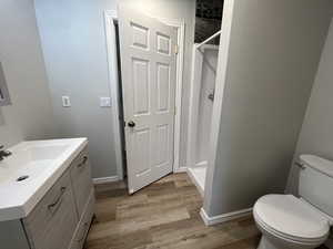 Bathroom featuring vanity, toilet, a shower stall, and wood finished floors