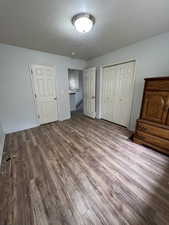 Unfurnished bedroom featuring a closet, wood finished floors, and baseboards