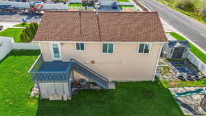 Rear view of house with an outbuilding, stairway, a fenced backyard, a storage unit, and a yard