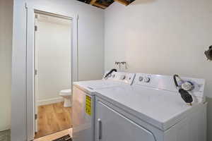Laundry room with laundry area, light wood-style flooring, and independent washer and dryer