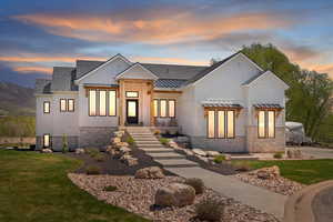 Modern farmhouse with a front yard, board and batten siding, metal roof, and a standing seam roof
