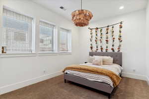 Carpeted bedroom with baseboards, recessed lighting, a chandelier, and visible vents