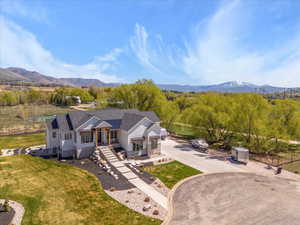 View of front of house with fence, a mountain view, driveway, a front yard, and board and batten siding