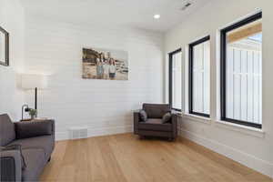 Sitting room featuring baseboards, light wood-type flooring, and visible vents