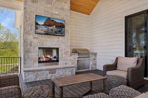 View of patio featuring area for grilling, an outdoor stone fireplace, and an outdoor kitchen