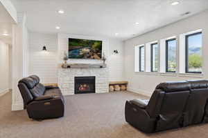 Carpeted living room with baseboards, recessed lighting, a stone fireplace, and visible vents