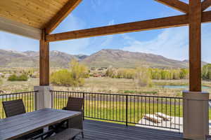 Deck featuring a water and mountain view and outdoor dining space