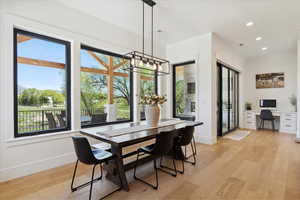 Dining space featuring baseboards, light wood-style floors, a chandelier, and recessed lighting