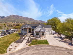 View of front of property featuring board and batten siding, driveway, a mountain view, an attached garage, and stone siding