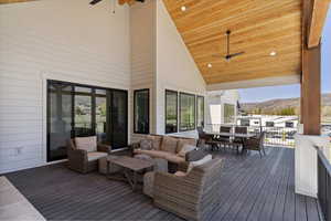 Deck with a mountain view, a ceiling fan, and outdoor dining space