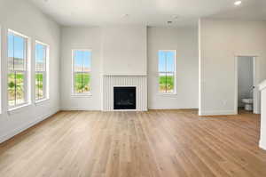 Unfurnished living room with plenty of natural light, light wood-style flooring, baseboards, and recessed lighting