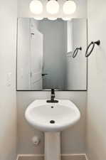 Bathroom featuring baseboards and a sink
