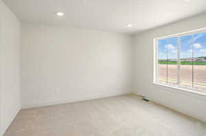 Unfurnished room with baseboards, recessed lighting, visible vents, and light colored carpet