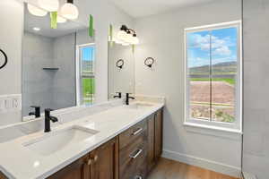 Full bath with a wealth of natural light, a sink, and wood finished floors