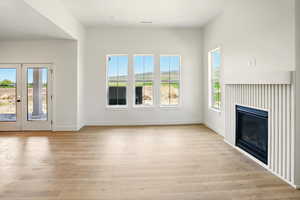 Unfurnished living room featuring light wood-style flooring, baseboards, and visible vents