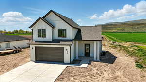Modern farmhouse style home featuring concrete driveway, roof with shingles, a mountain view, and a garage