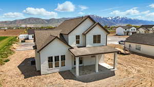 Back of property featuring central AC unit, a shingled roof, a mountain view, and a residential view