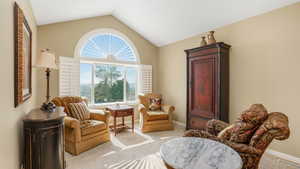 Sitting room with baseboards, carpet flooring, visible vents, and vaulted ceiling