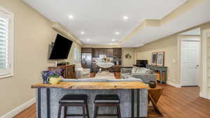 Living room featuring baseboards, recessed lighting, and light wood-type flooring
