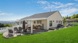Back of property with a yard, a patio area, stucco siding, and a fenced backyard