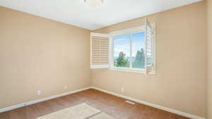 Unfurnished room with carpet flooring, visible vents, and baseboards