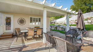 View of patio with outdoor dining space and fence