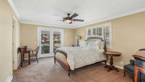 Primary Bedroom featuring crown molding, baseboards, a ceiling fan, and carpet